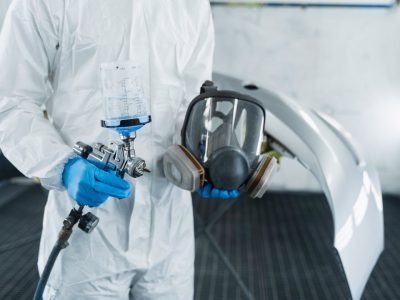 lose-up-view-of-car-painter-with-paint-gun-and-protective-respirator-in-hands-.jpg